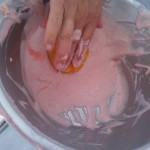 The method of dunking the spongecakes into the strawberry cream icing