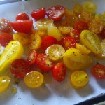 A mix of cherry tomatoes drizzled with olive oil, ready to be roasted