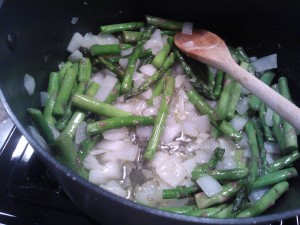 Sautéing the chopped yellow onion, garlic & asparagus spears in olive oil and butter