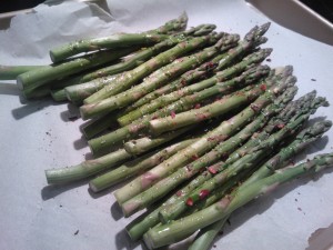 Asparagus spears drizzled with olive oil and seasoned, ready to be roasted