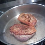 Searing the halved duck breasts