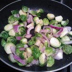 Sautéing the brussels sprouts and red onion in olive oil