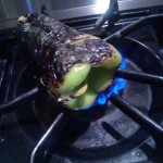 Roasting the poblano pepper over an open flame