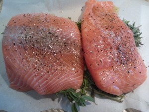 Salmon Filets on top of oregano sprigs, ready to be roasted