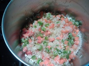 Toasting the rice and diced vegetables in olive oil