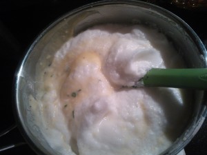 Folding the beaten egg whites into the flavored béchamel sauce 