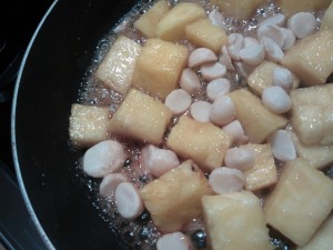 Cooking the fresh pineapple in the butter, brown sugar & rum, along with the macadamia nuts