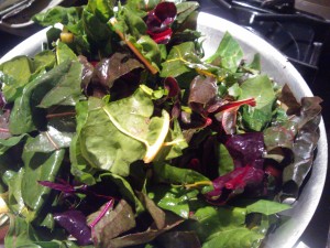 The colorful greens sautéing in the olive oil and garlic mixture