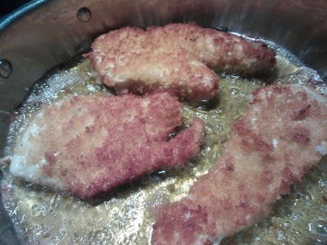 Cooking the breaded chicken cutlets in olive oil