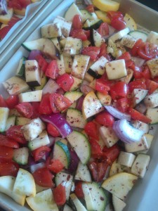 A mixture of yellow squash, zucchini, red onion, eggplant & cherry tomatoes, seasoned and ready to be roasted
