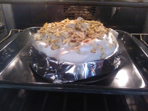 The cloud of meringue topped with almonds and ready to be baked