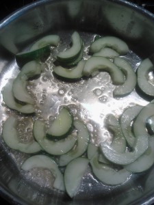 The sliced cucumbers cooking in a mixture of butter and olive oil