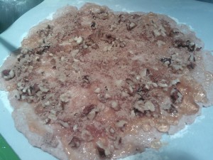 The homemade dough covered with jam and the walnut-mixture