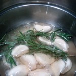 Cooking the garlic cloves with fresh rosemary, in a mixture of duck fat and canola oil